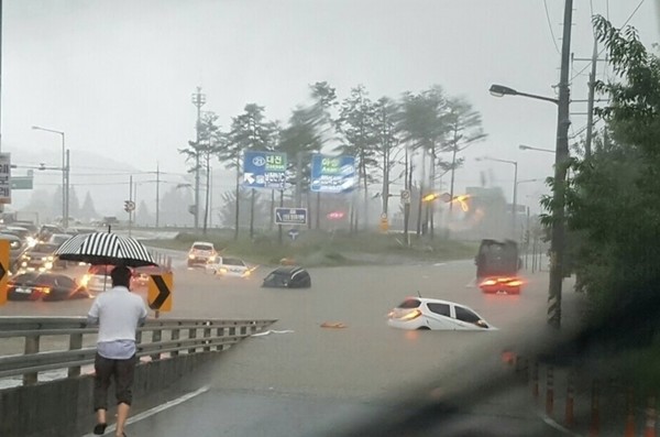 천안시 신방동 일대의 도로가 집중호우로 완전히 잠기며 차량 여러 대가 물에 반쯤 잠긴 채 정체되어 있다. (사진=독자제공)