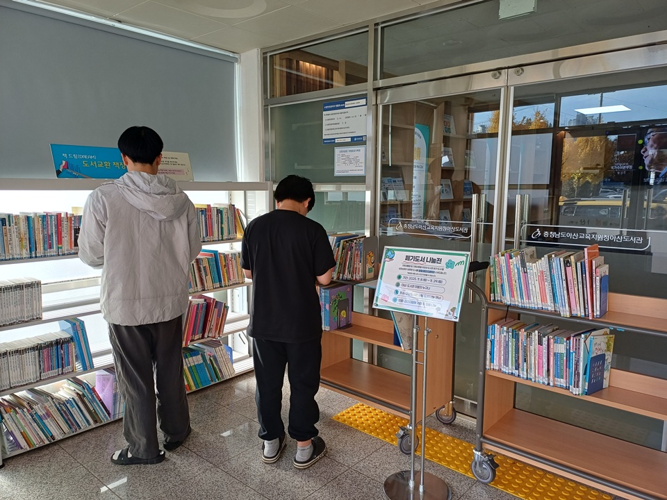 도서 나눔 코너에서 원하는 도서를 선택하고 있는 지역 이용자들의 모습(사진제공=아산도서관)