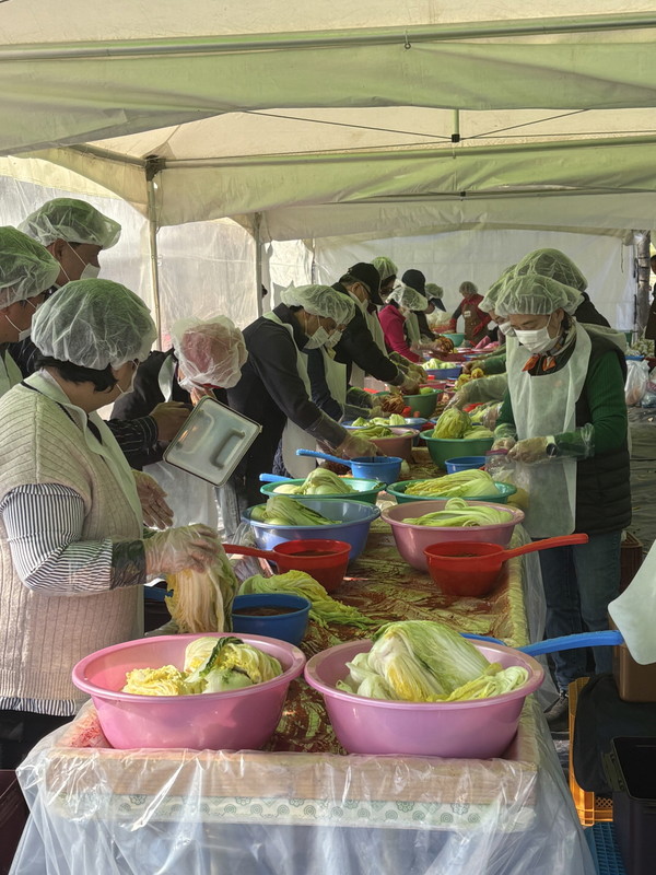 공주시금강신관공원에서 열린 ‘바로마켓 백제금강점 김장 재료 할인 판매 및 체험 행사’에서 행사 참여자들이 김장김치를 담그고 있다.[사진제공=공주시]