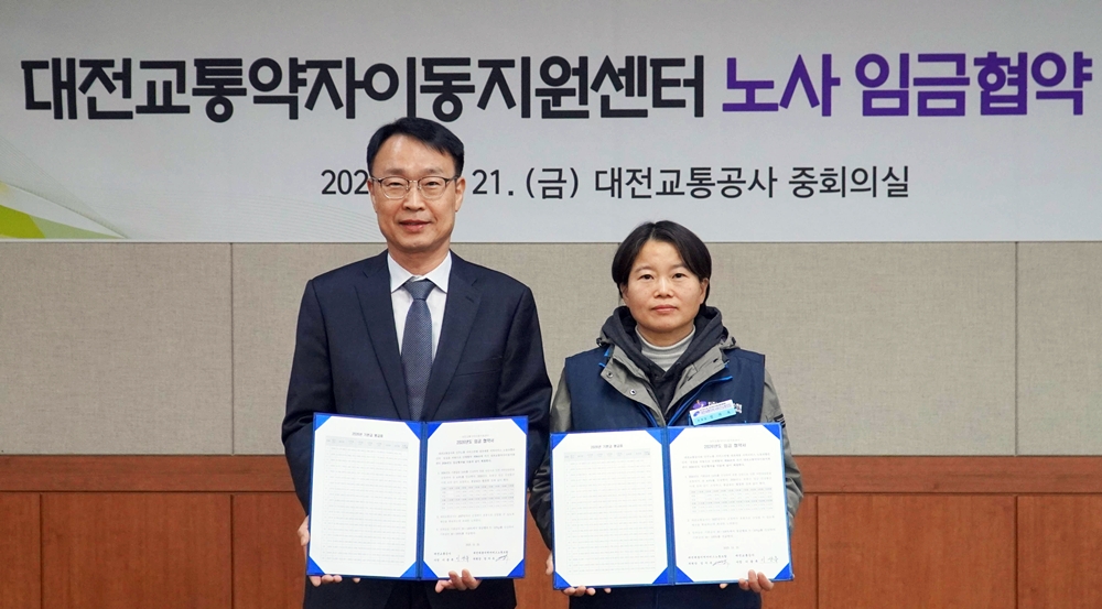 21일 대전교통공사 이광축 사장(왼쪽)과 민주노총 대전세종지역서비스노동조합 엄자옥 위원장(오른쪽)이 임금협약을 체결했다. (사진제공=대전교통공사)